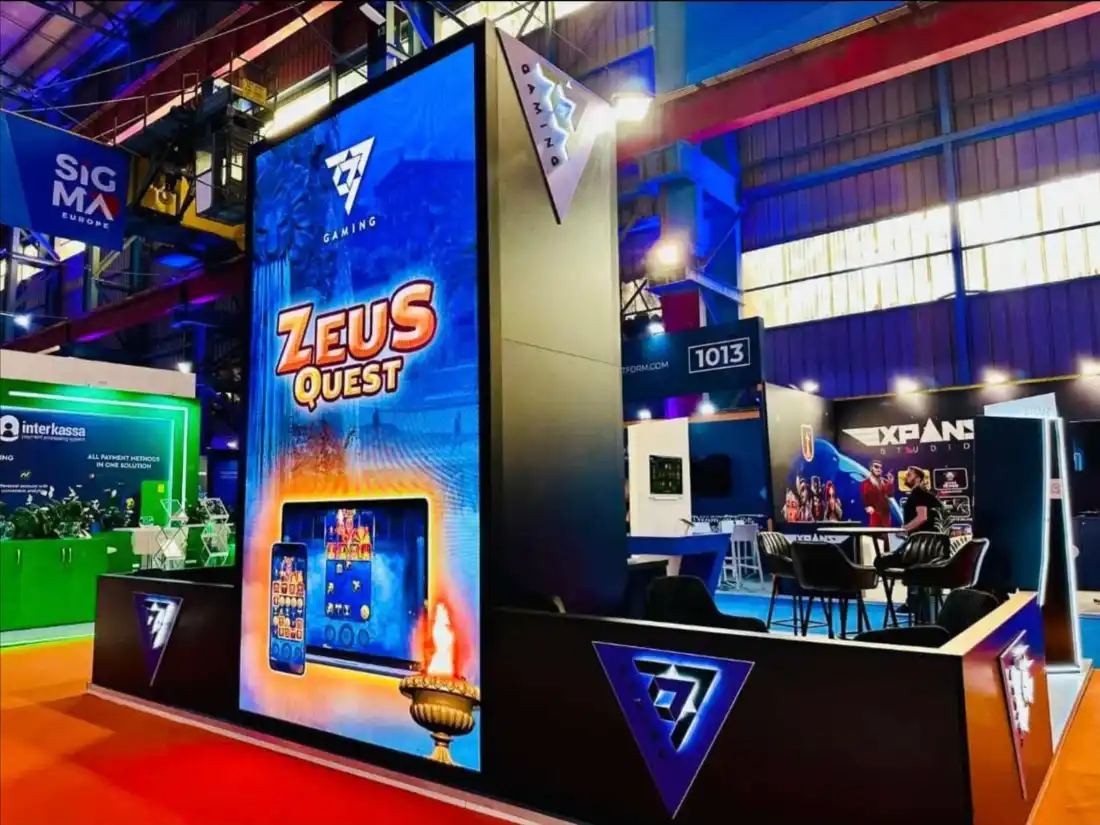 7777 Gaming stand at SiGMA Europe with a tall LED wall showing the game Zeus Quest