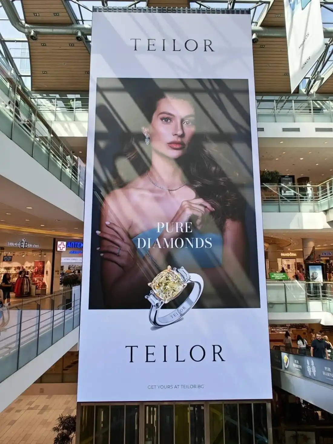 Hanging P3.9 LED screen in the atrium of The Mall under the glass roof, with patches of sunlight on the picture